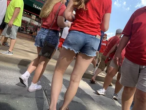 Bunch of girls in various outfits at a Cardinals baseball game