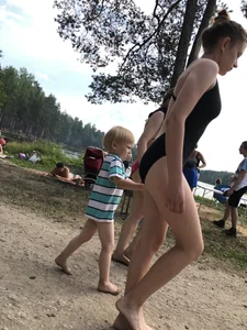 Cute Barefoot Girl in a Black Body Swimsuit Walking on a Road