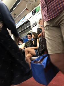 Hot Girl With Gorgeous Legs in Jean Shorts And Sneakers Sitting in a Subway Train With Crossed Legs - Touching And Swinging Her Legs