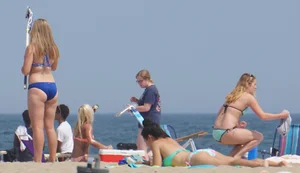 Cute girls in light blue and purple bikinis on the beach