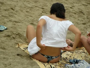 Sexy girl in a blue floral thong bikini at the beach