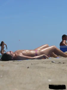 Purple thong topless lady on the beach gets oiled up by her husband
