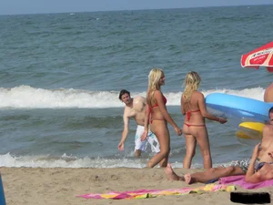 Sexy mom and daughter in red thongs at the beach