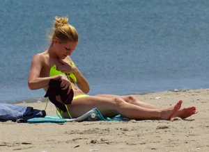 Sexy ass blonde milf on the beach in a thong with cameltoe and bending over