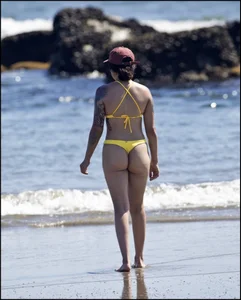 Sexy tattooed beach brunette with a great ass in yellow thong bikini