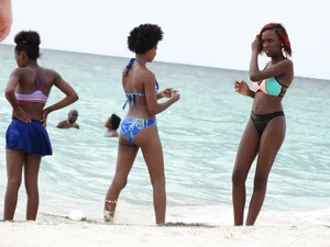 Candid black family, milf and teens on the beach in bikinis