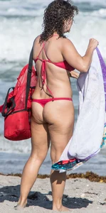Thick brunette milf on the beach in red thong bikini