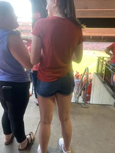 Bunch of girls in various outfits at a Cardinals baseball game