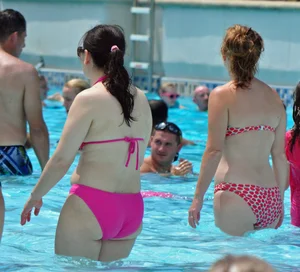 Thick brunette lady in the pool in a pink bikini