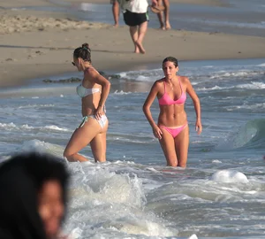 Two sexy friends out on the beach in bikinis