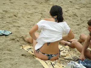 Sexy girl in a blue floral thong bikini at the beach