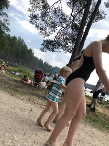 Cute Barefoot Girl in a Black Body Swimsuit Walking on a Road