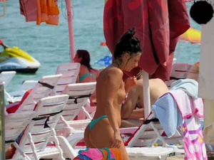 Brunette topless babe with cute tits and a nice ass in a thong bikini
