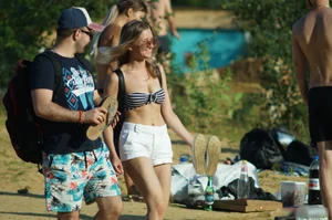 Hot Girl in Sunglasses, Swimsuit Top and Shorts Walking on the Beach Pics