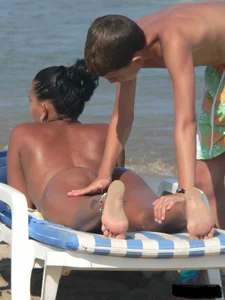 Hot ass topless beach girl with great tits lets her little brother oil up her ass in thong bikini
