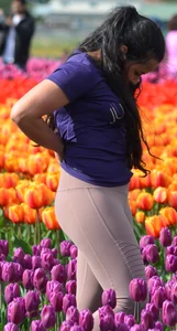 Cute babe in tight leggings taking pictures in flower fields