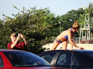 Group of cute girls at a car wash in bikinis and shorts