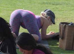 Blonde in Purple Yoga Pants Standing Doggy Style on the Park Lawn