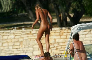 Two sexy nude beach friends getting some sun