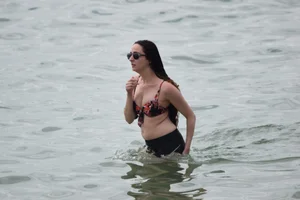 Brunette girl in black shorts and bikini top on the beach
