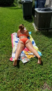 Chubby Girl in a Red Swimsuit Lying on Her Tummy on the Grass with Spread Legs Candid Pic