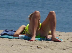 Sexy ass blonde milf on the beach in a thong with cameltoe and bending over