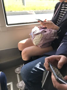 A Very Cute And Skinny Candid Teen Girl Wearing Glasses, A Skirt And Knee Socks Sitting in a Public Bus, Closeups of Her Legs