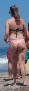 Chunky beach blonde babe in a pink thong bikini