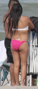 Brunette bikini girl on the beach and surfing in her bikini