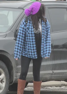 A cute brunette in leggings boots and hat