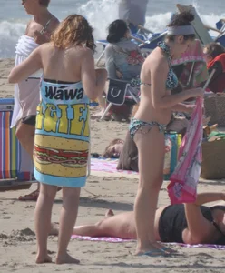 Bikini girls setting up for a day on the beach in their bikinis