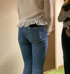 Perfect tight butt in blue jeans, candid girl wearing a blouse