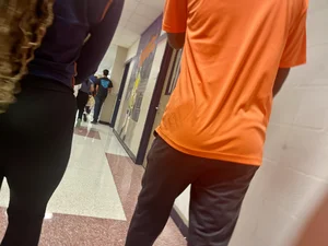 College teen wearing tight pants walking down the hall