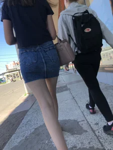 Cute Girl in a Short Denim Skirt Walking on a Street And Waiting on a Crosswalk Gallery