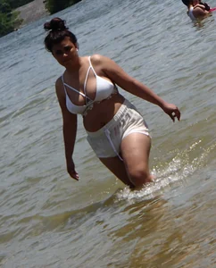 Big boobed brunette on the beach in white bikini