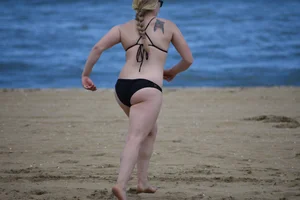 Chunky blonde in a black bikini on the beach