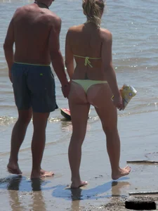 Sexy blonde on the beach in a yellow thong bikini