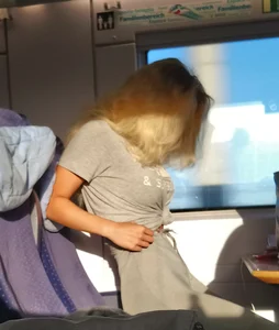 Skinny blonde girl pulling up her pantts in the public train
