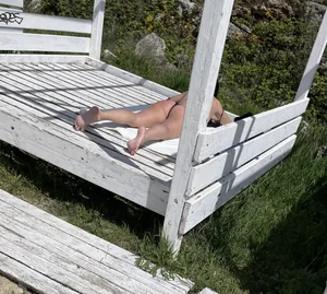 Awesome candid milf in a swimsuit sunbathing