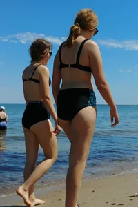 2 sexy friends in bikinis walking on the beach