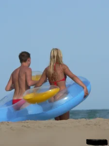 Sexy mom and daughter in red thongs at the beach