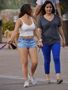 Sexy dog walker in shorts and tank top with friend in blue jeans