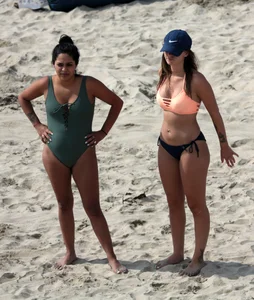 Big boobed babe with pokies in a bikini on the beach with friends