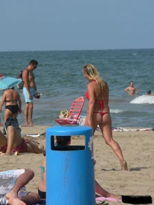 Sexy mom and daughter in red thongs at the beach