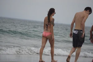 Peach bikini tattood babe on the beach with a nice ass and some camel toe