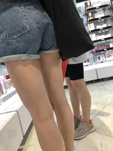 Skinny candid teen's legs and booty in denim shorts closeups at the store