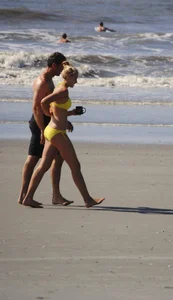 Skinny cute blonde on the beach in yellow bikini