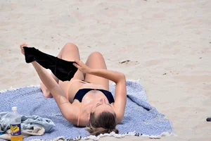 Blue bikini girl on the beach with a great ass and a little pussy lips slips