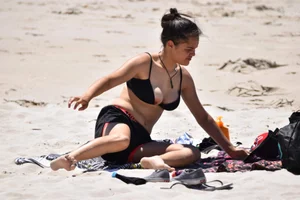 Beach girl can't keep her tits in her bikini