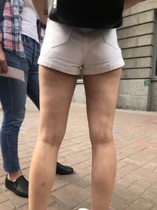 Hot Candid Girl in a Top, Shorts and Sneakers Skinny Legs Closeup Creepshots Gallery on the City Street